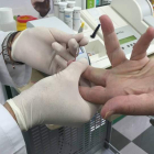 El farmacéutico realiza una prueba para la detección rápida del virus del sida a un usuario.