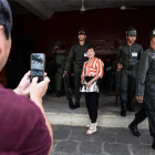 Una turista se fotografía con unos soldados en Bangkok, Tailandia.