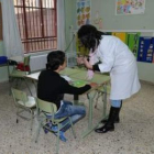 Una profesora de educación especial atiende a un alumno durante la clase.