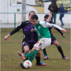 Taranilla golpea el balón obstaculizado por un jugador rival.