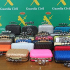 Los bolsos que habían sido intervenidos, junto con una imagen de la destrucción de las 957 armas por la Guardia Civil.