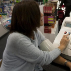 Una mujer se toma la presión en una farmacia en Barcelona.