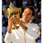 Federer mira la copa con orgullo tras proclamarse por sexta vez campeón de Wimbledon.