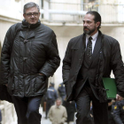 García Revenga y su abogado salen de los juzgados.