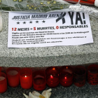 Un cartel, flores y velas a los pies del árbol plantado en memoria de dos de las víctimas.