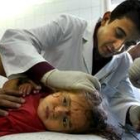 Un médico cura a una niña palestina herida en los bombardeos de Gaza