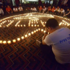 Familiares de pasajeros del vuelo Malaysia Airlines MH370 rezan en el Metro Park Hotel en Pekin.