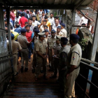 Policías inspeccionan el lugar de la estampida en un puente de peatones sobre las vías de tren, en Bombay, el 29 de septiembre