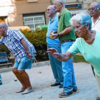 Un grupo de pensionistas juega a petanca en un parque.