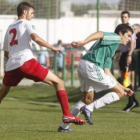 El jugador del Astorga Mario Villar intenta zafarse del marcaje del lateral del Santa Marta Oli.
