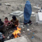 Varios niños combaten el frío alrededor de una hoguera en un cementerio de Kabul.