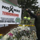 Un hombre extiende una pancarta durante un homenaje a los cadetes muertos por la explosion del carro bomba contra la Escuela de Cadetes de la Policia General Santander en un ataque atribuido a la guerrilla del ELN.