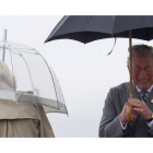 El príncipe Carlos se protege de la lluvia a su llegada a Winnipeg (Canadá), este martes.