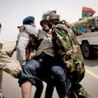 Rebeldes libios trasladan a un compatriota herido en un ataque de las fuerzas de Gadafi.