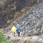 Dos senderistas pasan por la zona del desprendimientos en la ruta del Cares.