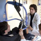 Dos médicos ayudan a la rehabilitación de uno de los enfermos que acuden al centro estatal de Burgos