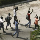 Civiles caminan con las manos en alto para mostrar que van desarmados en Abiyán.