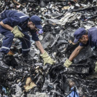 Dos agentes buscan entre los restos del vuelo MH17 de Malaysia Airlines, el pasado 20 de julio en Donetsk (Ucrania).