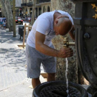 Un turista se refresca en la fuente de Canaletes, en la Rambla de Barcelona. /