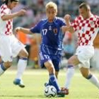 Inamoto lucha por el balón ante dos croatas durante el partido de ayer