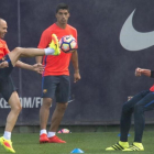 Iniesta golpea el balón ante Suárez y Ter Stegen durante la sesión de entrenamiento de este lunes