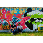 Guillermo y Luis delante del grafiti que han hecho en los muros de los depósitos de agua de Eras de Renueva.