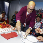 Carmelo Ezpeleta reparte, en presencia de Marc Márquez y sus compañeros, el pastel de su 70 cumpleaños.