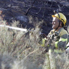 Un bombero trata de luchar contra las últimas llamas del incendio.