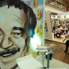 Una pareja pasa frente a una ilustración de Gabriel García Márquez en la Feria Internacional del Libro de Bogotá