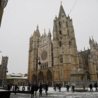 Gente junto a la Catedral de León este sábado, durante la nevada. FERNANDO OTERO