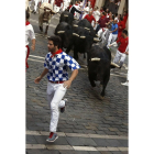 Los mozos corren, por la calle Mercaderes, delante de los toros de la ganadería madrileña de Victoriano del Río que han protagonizado el cuarto encierro de los sanfermines, el más rápido que ha finalizado en 2 minutos y 11 segundos, y que ha sido muy peli