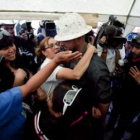 Familiares de los mineros atrapados abrazan a un operario de la máquina Schramm T-130.
