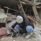 Una niña rescata a un perro de los escombros de un edificio atacado en Lviv. MYKOLA TYS