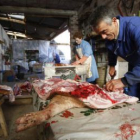 Dos vecinos de Benavides de Órbigo despiezan el cerdo durante una matanza domiciliaria.