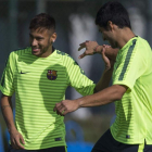 Neymar bromea con Luis Suárez durante el entrenamiento de ayer.