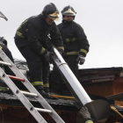 Los bomberos retiran la chimenea de la cubierta afectada por el fuego.