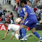 El capitán blanco, Raúl, pugna por un balón en el suelo con dos jugadores del Getafe