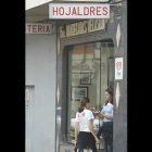 Dos jóvenes disfrutan de los manjares de una de las fábricas de hojaldres y mantecadas de Astorga, productos típicos de la ciudad.