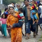 Una madre huye con su familia después de recibir el aviso de que otro terremoto podría azotar Gunung