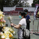 Dos mujeres colocan flores en el memorial a las víctimas de Tiananmen, en Hong Kong.