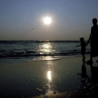 Un hombre y su hijo pasean por la playa en una de las islas de Andamán, en la India. MANJUNATH KIRAN
