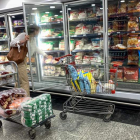 Una mujer busca un producto en un lineal de frío de un supermercado. MIGUEL GUTIÉRREZ