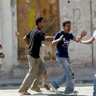 Unos jóvenes ayudan a otro palestino después de que recibiera un tiro en la cara en Askara
