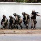 Un grupo de soldados norteamericanos se parapeta tras un muro en Bagdad