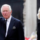 Carlos III, acompañado por Camila, saluda a las personas congregadas en el acceso al palacio de Buckingham para darle el recibimiento popular. OLIVIER HOSLET