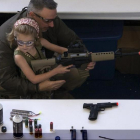 Un hombre muestra a una niña cómo coger una escopeta de aire comprimido durante el NRA Youth Day, en la reunión anual de la NRA, en Houston, en el 2013.