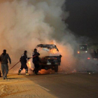 Bomberos egipcios apagan el fuego de varios vehículos que han sido quemados durante los disturbios de este domingo.