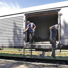 Expertos forenses holandeses saltan de un vagón refrigerado tras revisar alguno de los cadáveres de las víctimas del vuelo MH17 en una estación de tren de Torez, a unos 90 kilómetros al este de Donetsk (Ucrania) hoy, lunes 21 de julio de 2014.