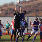 El meta Omar bloca un balón aéreo y evita el remate de un jugador bañezano. L. DE LA MATA