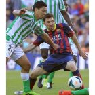 Reyes intenta quitarle el balón a Messi, bigoleador del Barça.